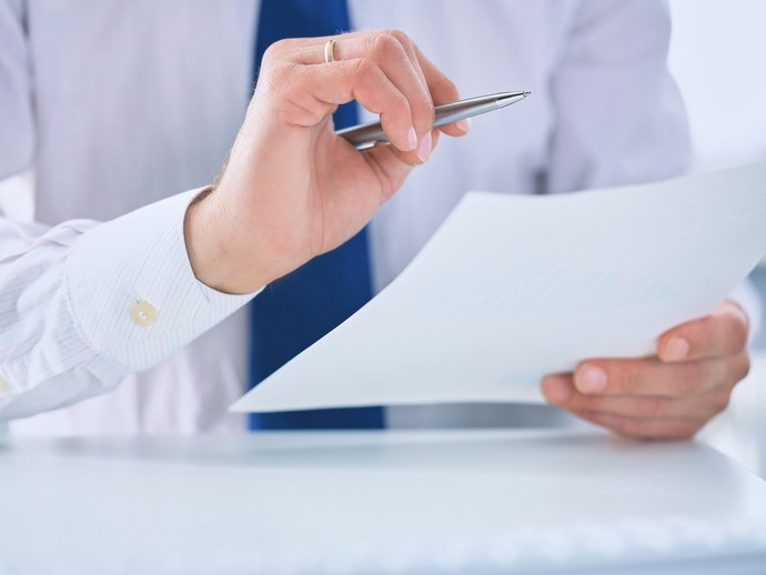 Das Bild zeigt eine Hand mit Kugelschreiber und ein Blatt Papier. Quelle:  © stock.adobe.com