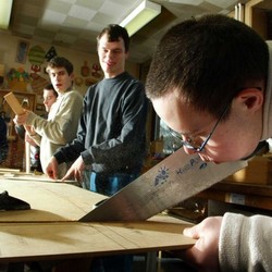 Auf dem Bild sind mehrere Menschen zu sehen, die in einer Werkstatt für behinderte Menschen arbeiten.