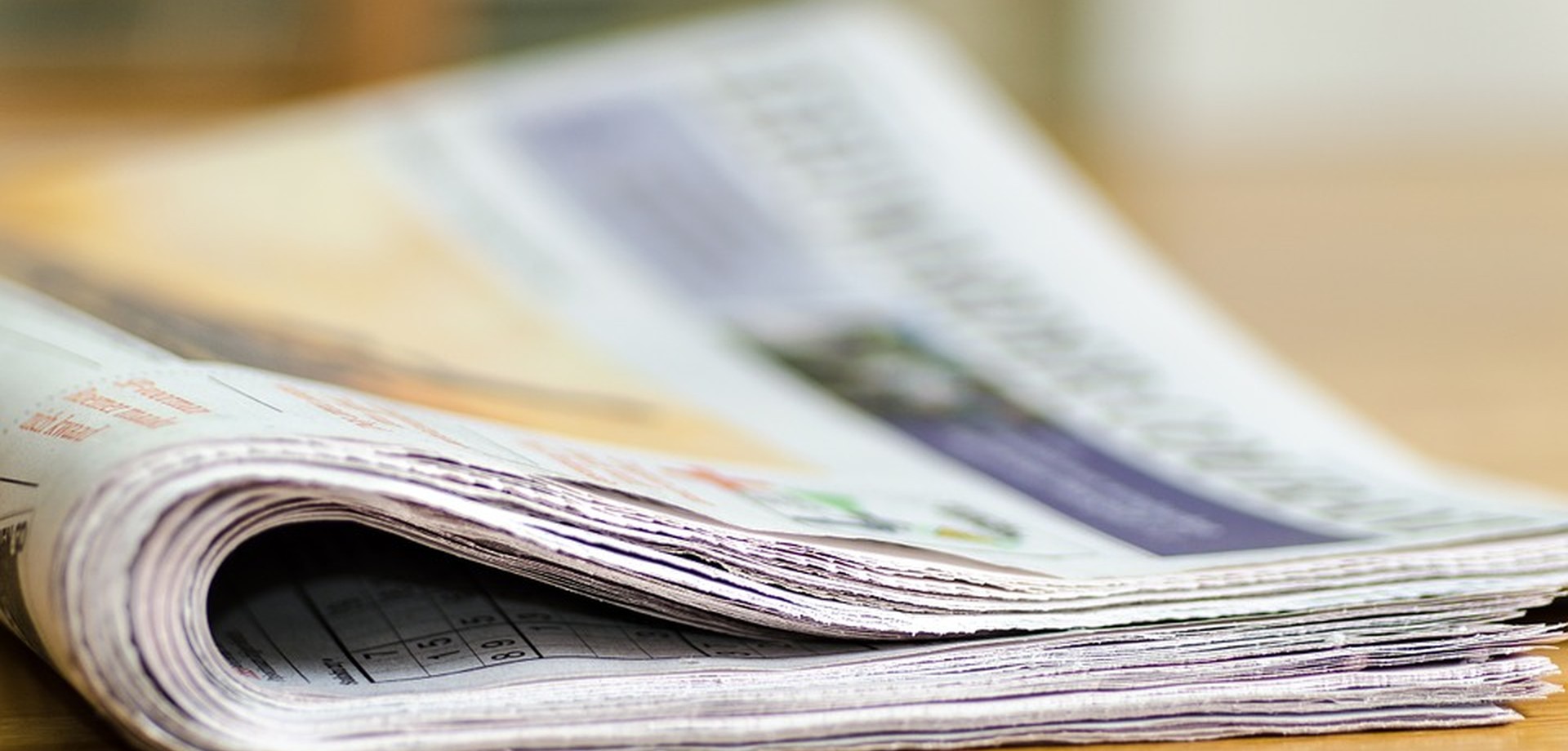 Eine gefaltene Zeitung liegt auf einem Tisch. Quelle: © Andrys/pixabay.com